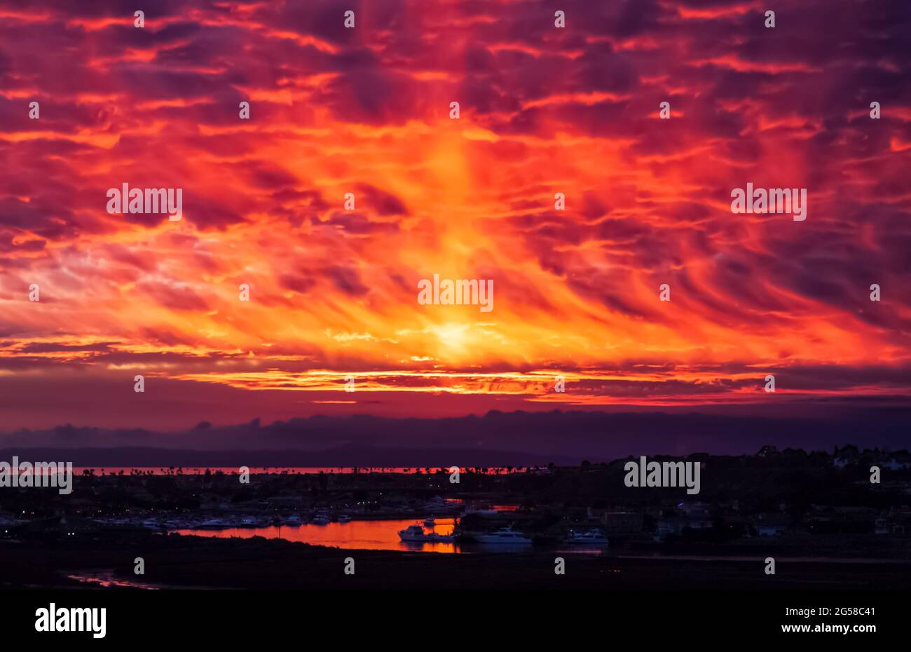 fiery sunset reflected in water upper back bay in Newport Beach California Stock Photo