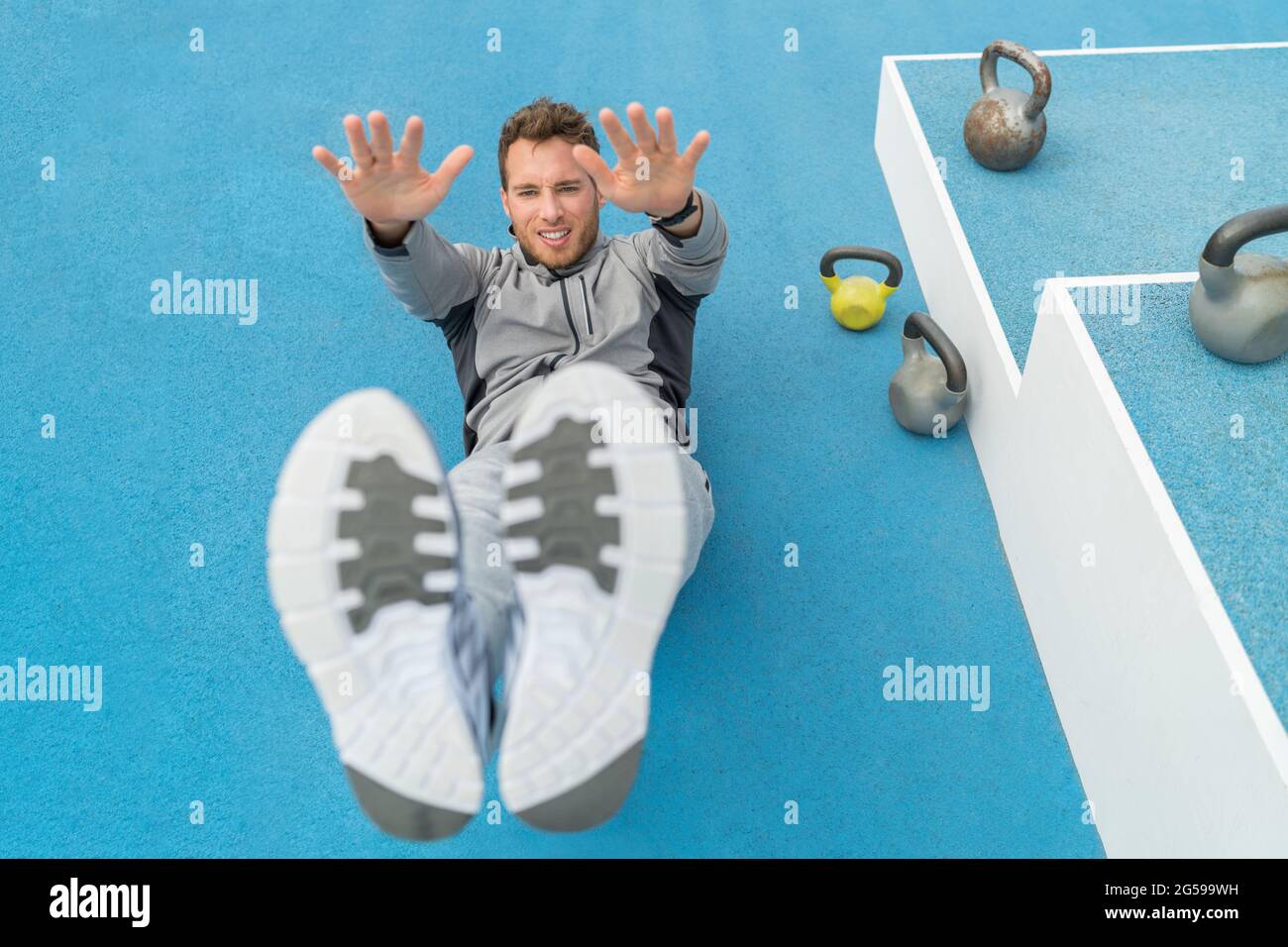 Abs exercise leg lift toe touch situp workout man strength training at fitness gym athletic