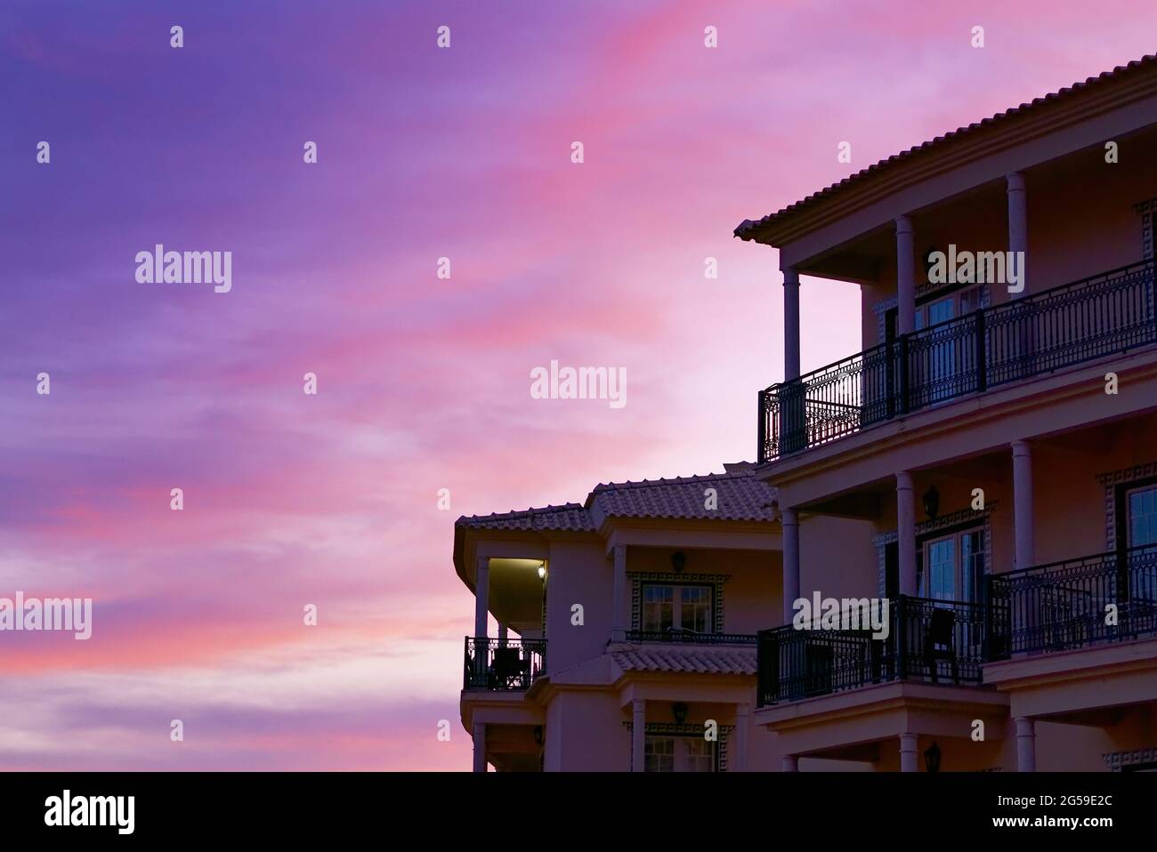 Building with balconies under the beautiful pink sunset sk Stock Photo ...