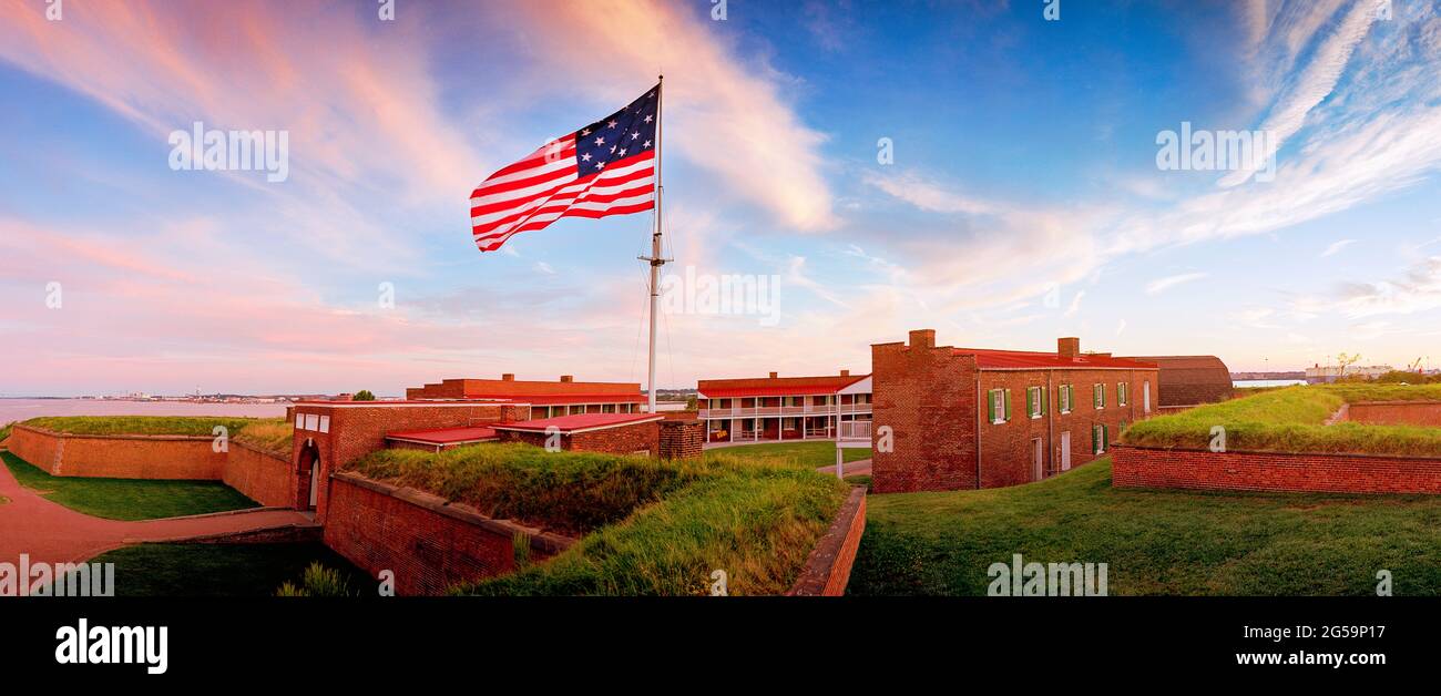Flag waves over Fort McHenry in Baltimore MD. Fort McHenry above the Patapsco River on 4th July, USA Stock Photo