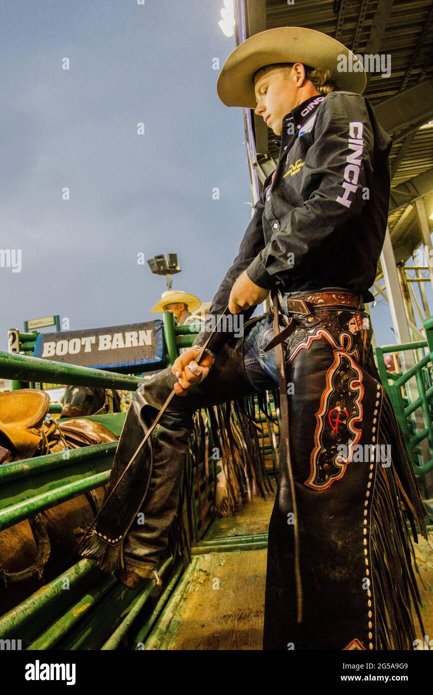 Reno, United States. 24th June, 2021. A cowboy tightens the front cinch ...