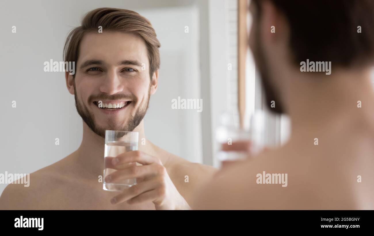 Happy attractive millennial guy drinking good pure fresh water Stock Photo