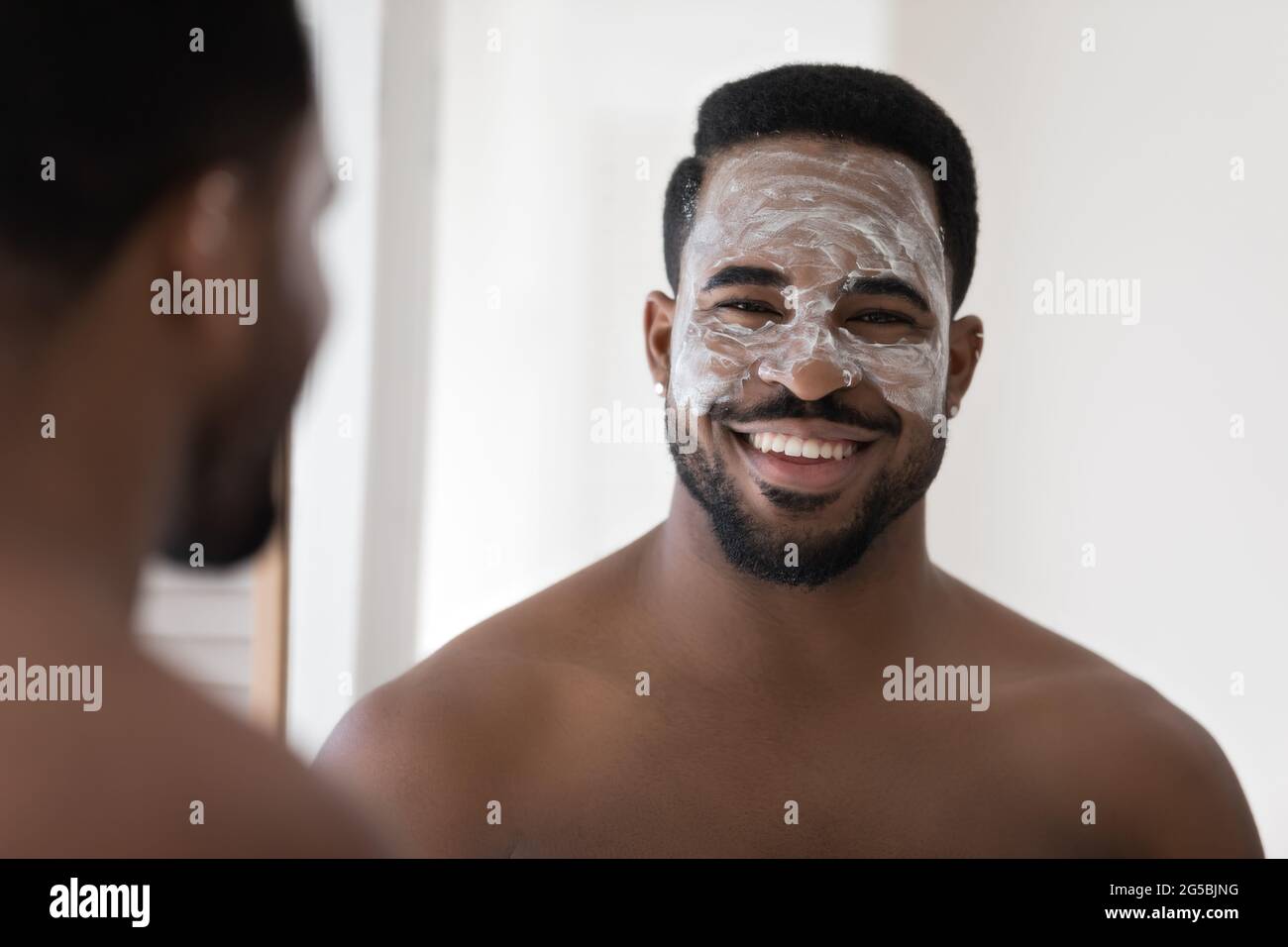 Happy attractive African guy with white cleansing natural scrub Stock Photo