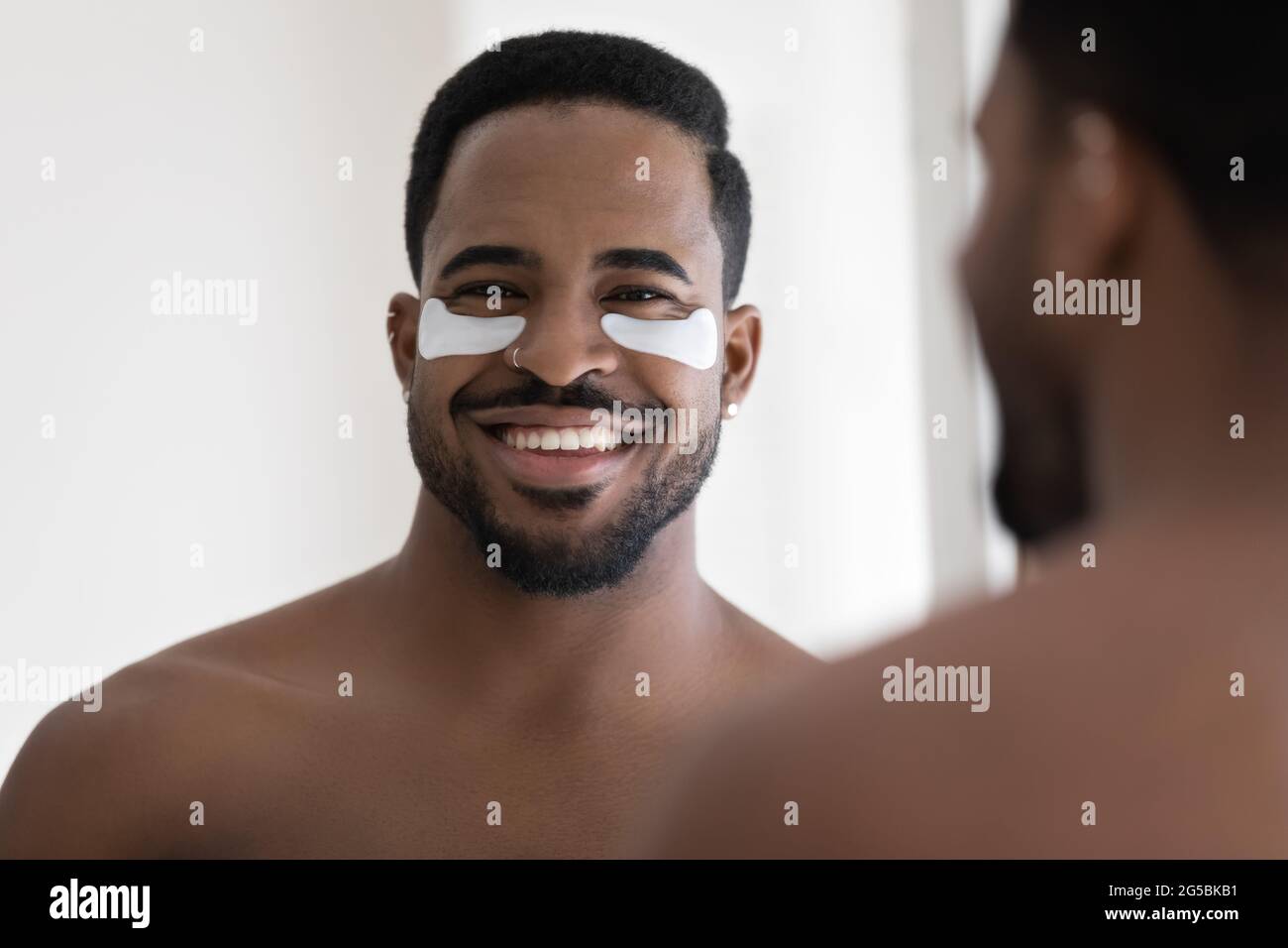 African American guy with applied patches on under eye skin Stock Photo