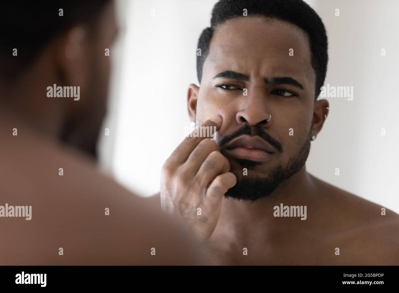 Concerned metrosexual young Black guy with stylish beard Stock Photo