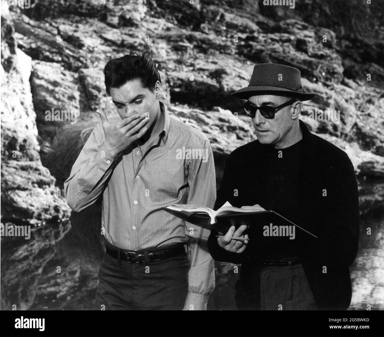 ELVIS PRESLEY and Director PHILIP DUNNE on set location candid checking script during filming of WILD IN THE COUNTRY 1961 director PHILIP DUNNE from the novel The Lost Country by J.R. Salamanca screenplay Clifford Odets Jerry Wald Productions / Twentieth Century Fox Stock Photo