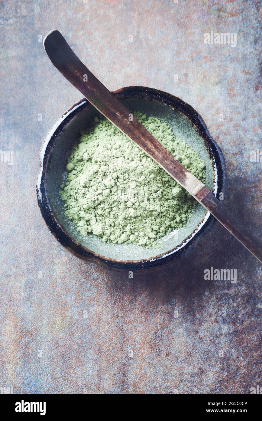 Powdered matcha green tea and chashaku matcha spoon on rustic stone background. Top view. Close up. Copy space. Stock Photo