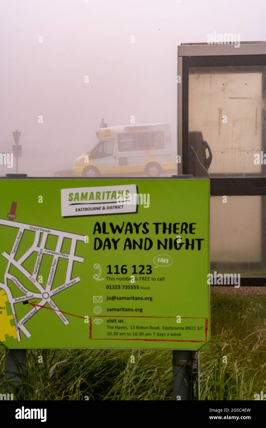 An ice cream van sits in thick fog at Beachy Head by a Smaritans sign Stock Photo