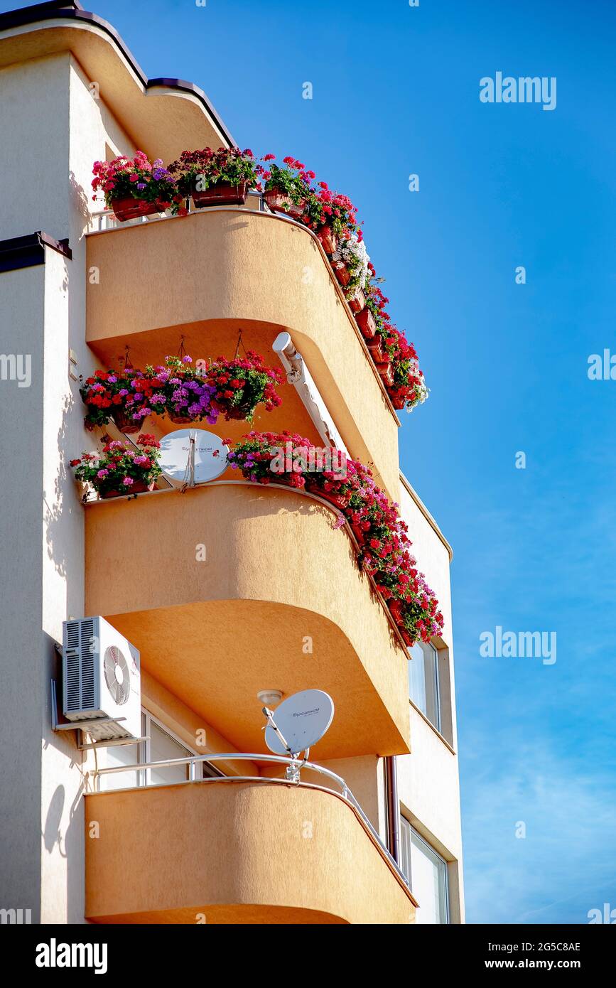 Flower covered balcony on a European street in summer Stock Photo
