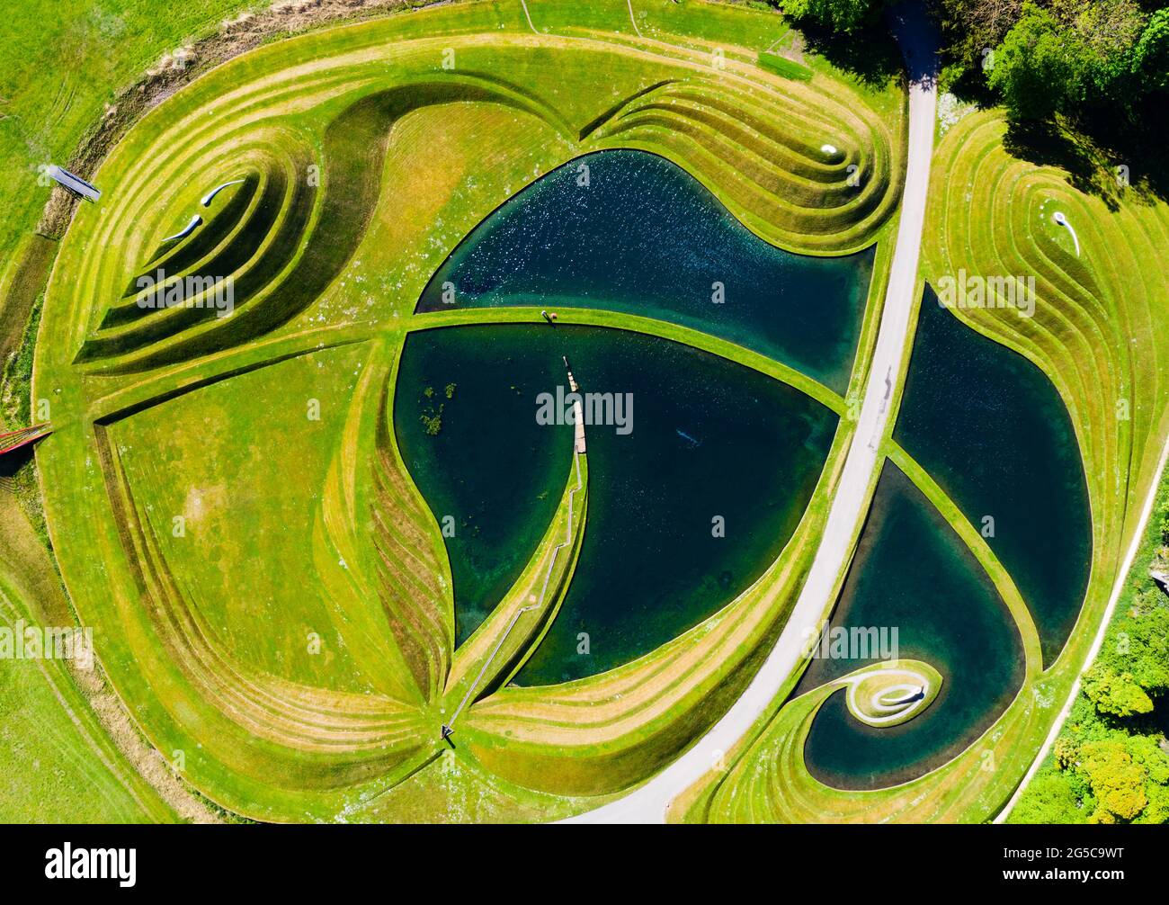 Thomas Unterdorfer, Keeper of the Landscape at Jupiter Artland, cutting grass on the landform sculptures, Scotland, UK Stock Photo