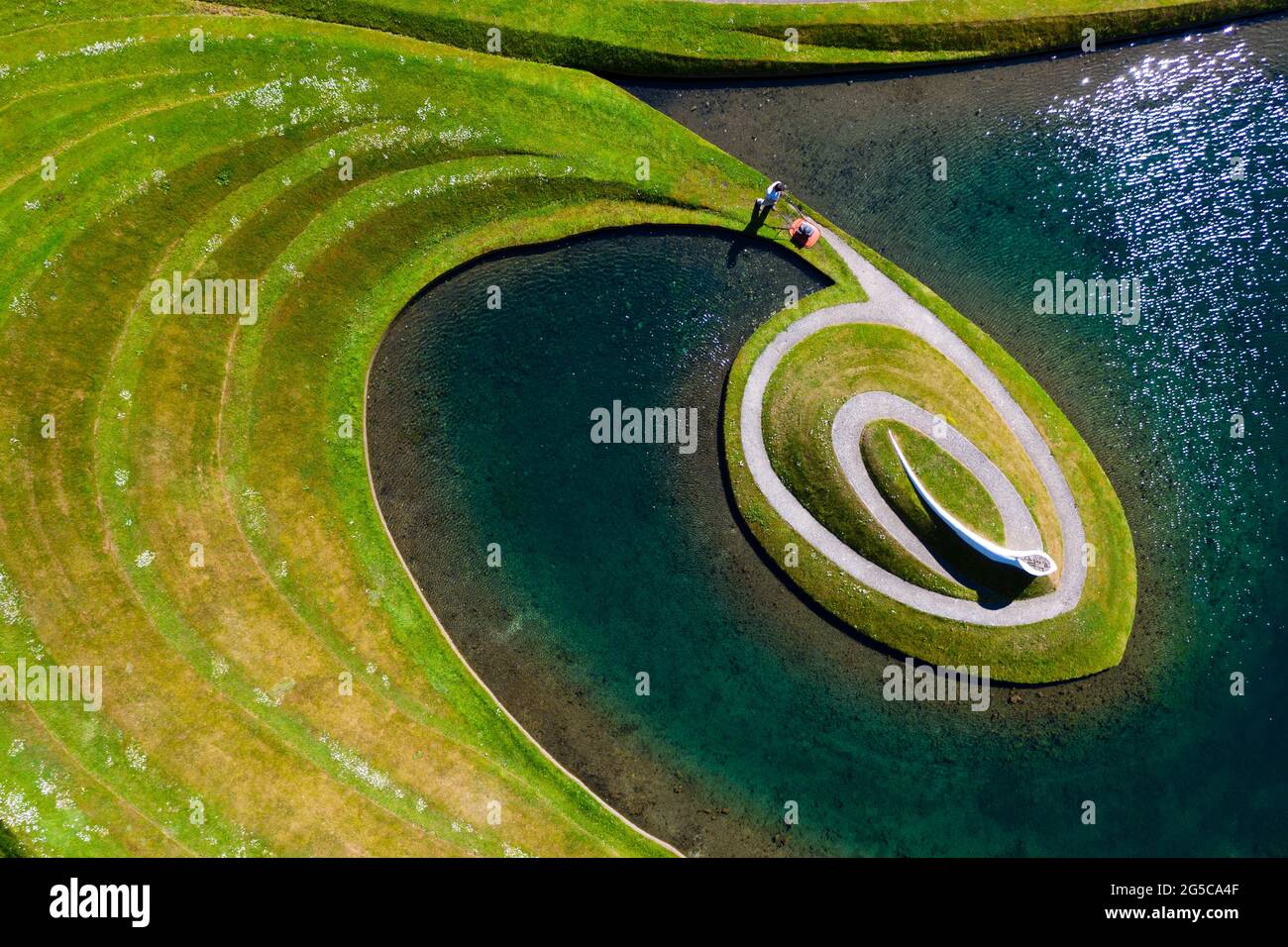Thomas Unterdorfer, Keeper of the Landscape at Jupiter Artland, cutting grass on the landform sculptures, Scotland, UK Stock Photo