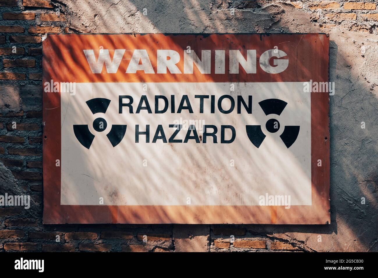 radiation hazard warning sign on the wall at forbidding entry aria to a radioactive zone. Stock Photo