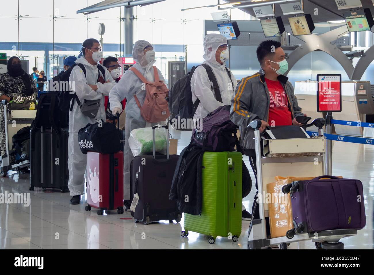 Bangkok, Thailand - June 2, 2021 : asian passengers wearing ppe suit to protect from covid-19 or coronavirus to check in before flight at airport. Stock Photo