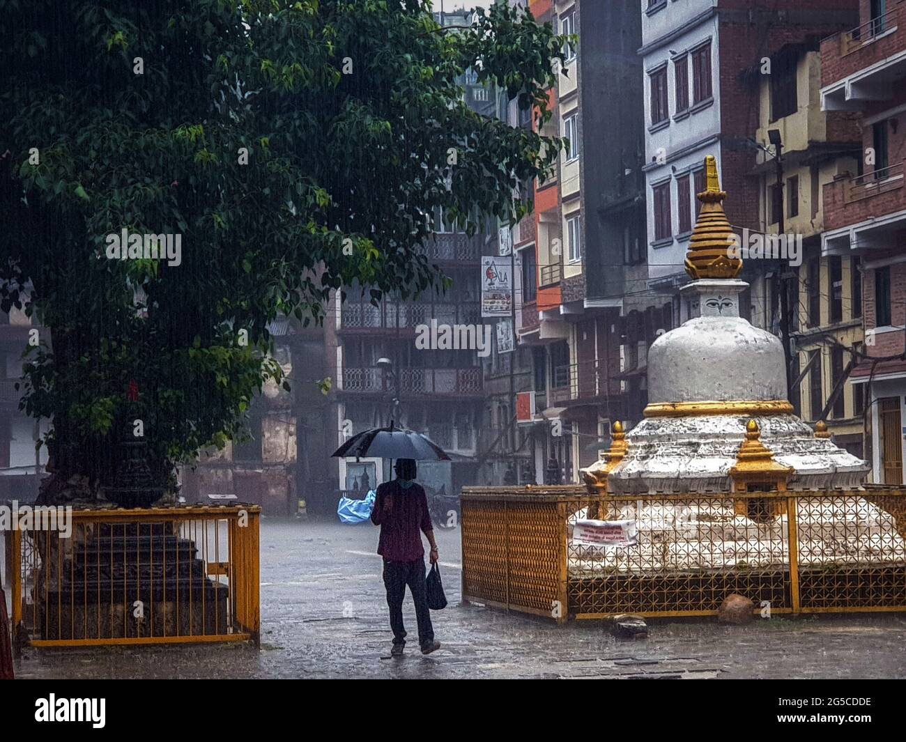 Kathmandu, Bagmati, Nepal. 26th June, 2021. A man walks under umbrella