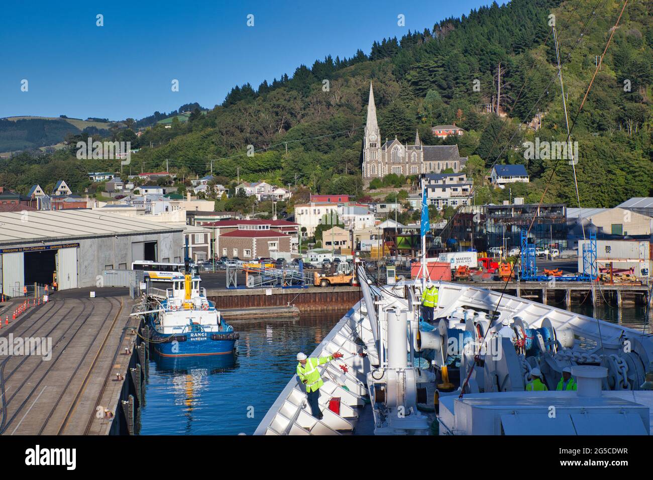 The deck and bows of a ship when docking at Port Chalmers on the east coast of South Island, New Zealand, with men in visability jackets Stock Photo
