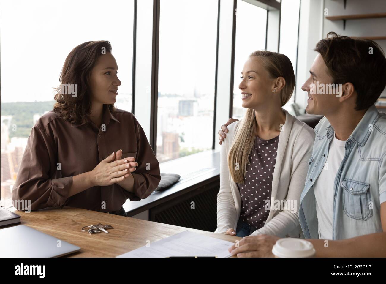 Skilled realtor consulting clients at office meeting Stock Photo - Alamy