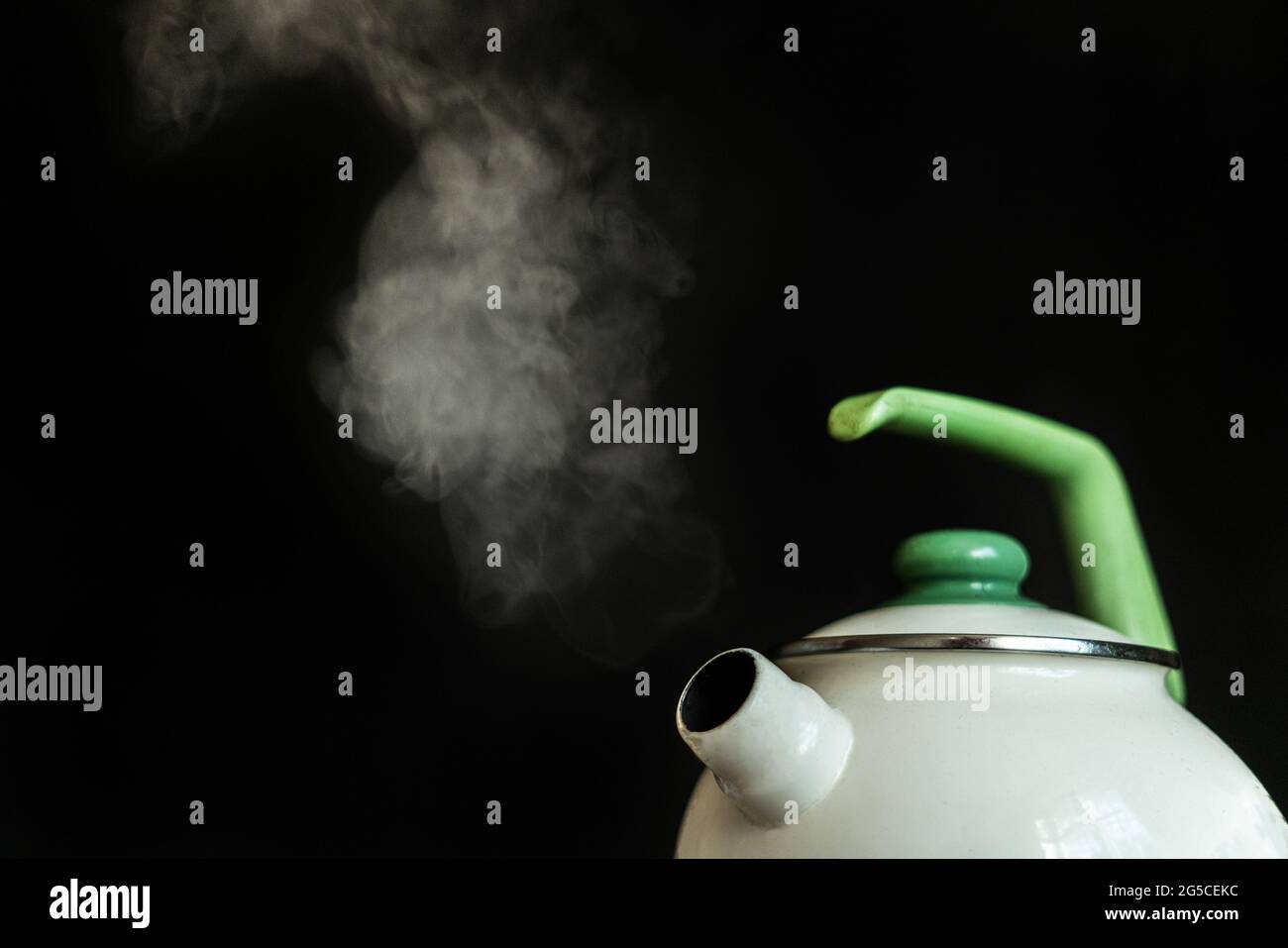 the kettle with hot boiling water and the steam comes out from it on