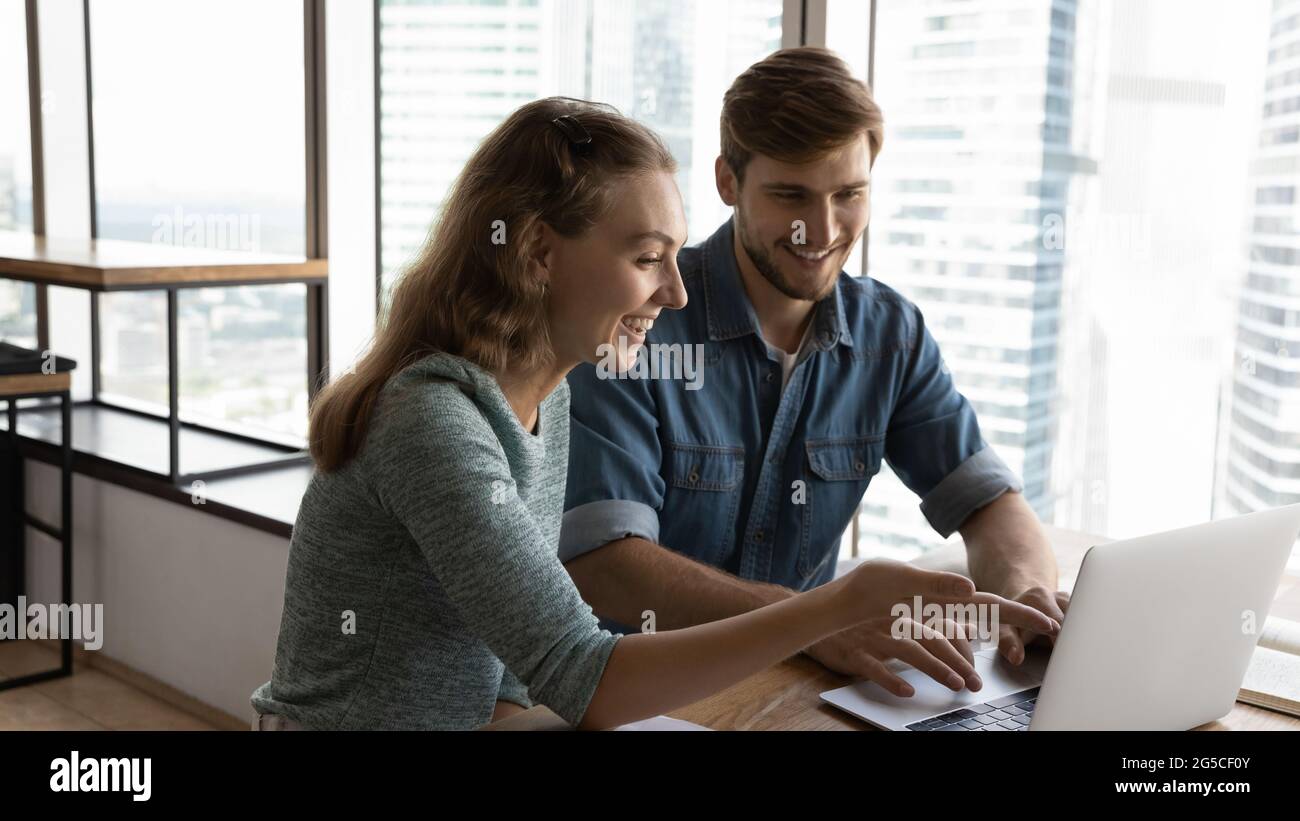 Happy two colleagues working on online project. Stock Photo