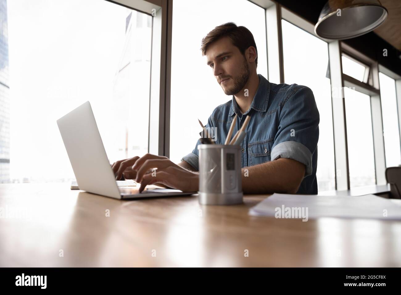 Focused young male manager working on computer. Stock Photo