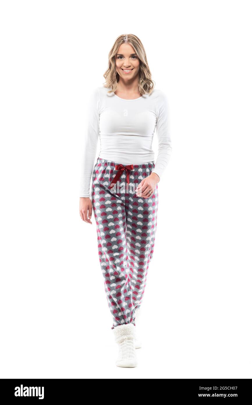 Happy young pretty woman walking towards camera in comfy sleepwear