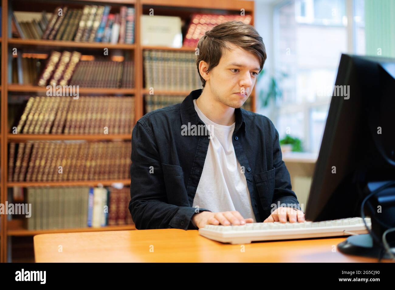 young male student manager in the college doing study work with books ...