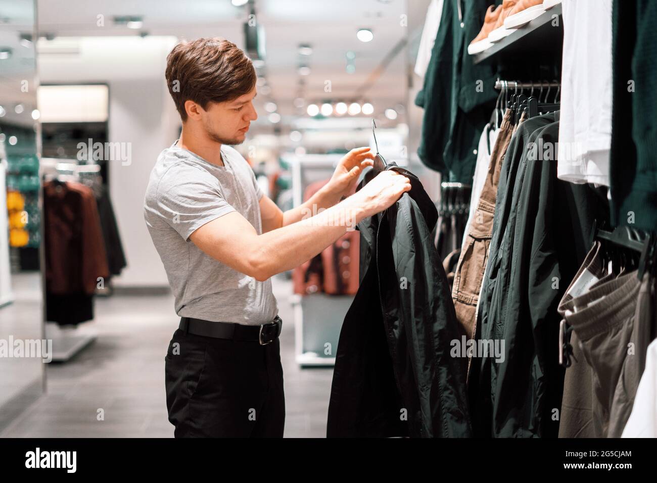 it's shopping time. young man in the casual clothes store Stock Photo ...