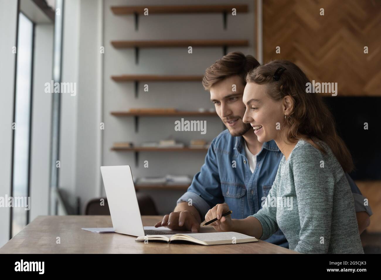 Joyful young family couple using computer apps. Stock Photo