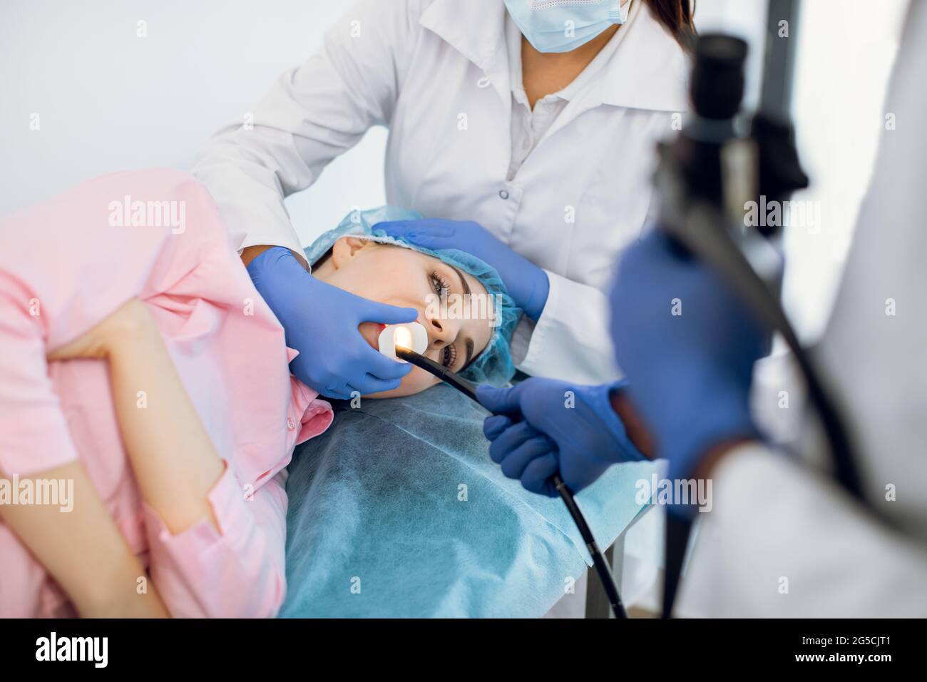 Young woman patient lying on the couch in modern clinic, having gastroscopic examination of the stomach and digestive tract Stock Photo