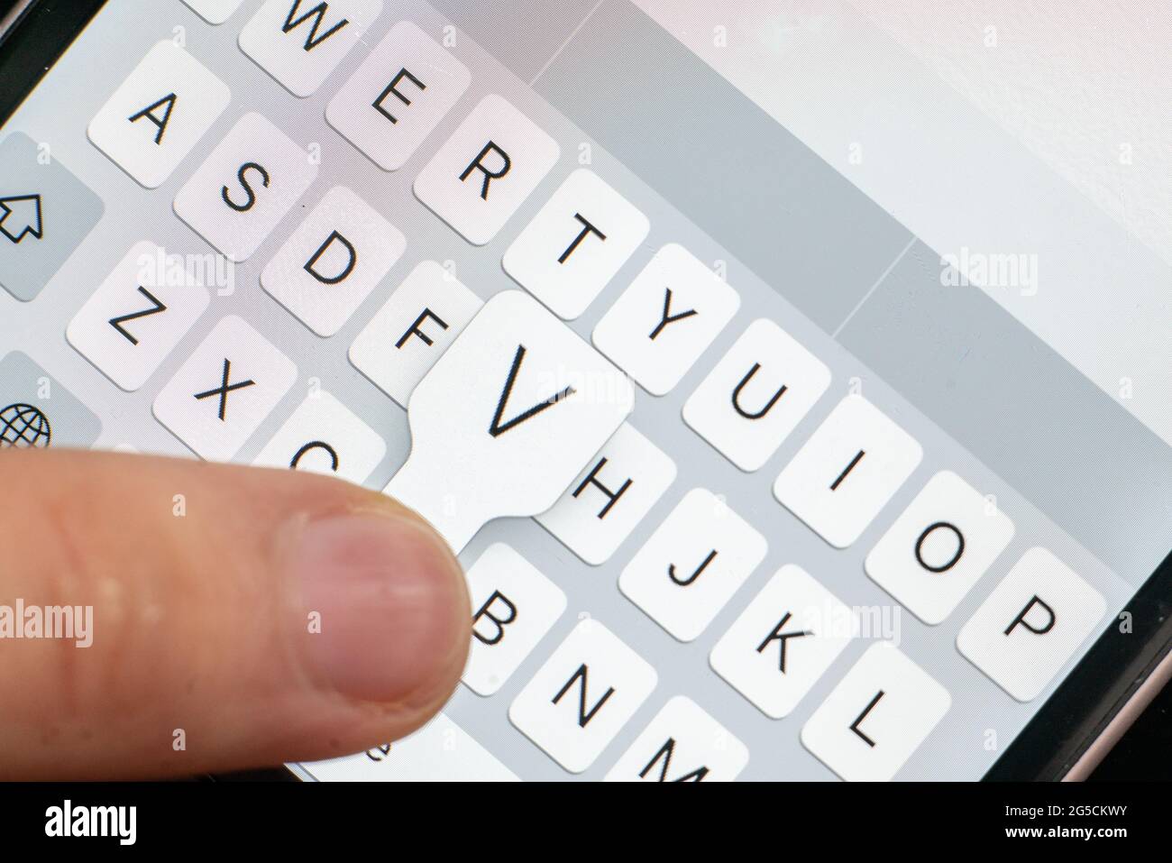 macro of a finger typing text on the touch screen keyboard of mobile