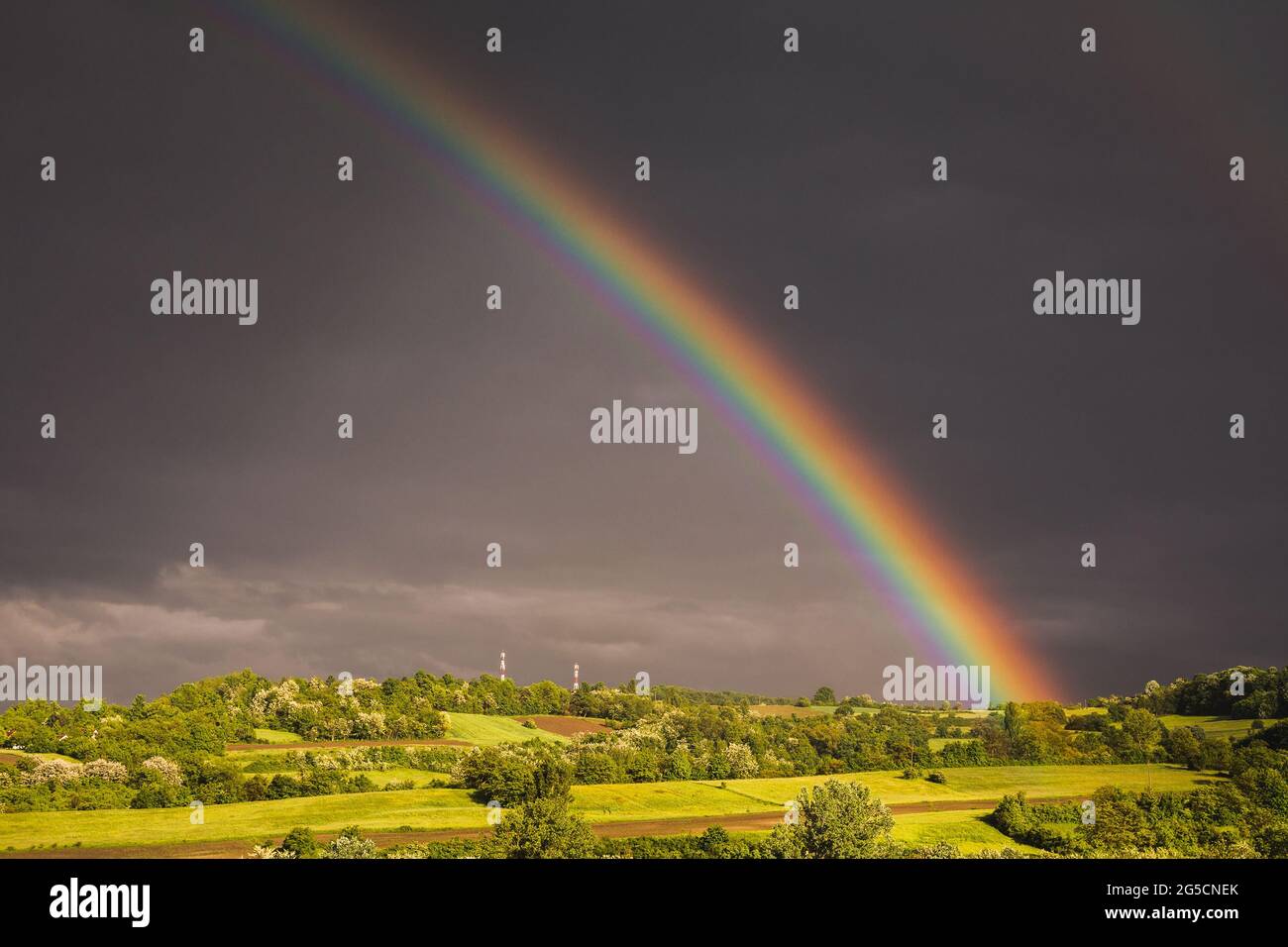 Beautiful view of a rainbow in the gloomy sky after the rain over the ...