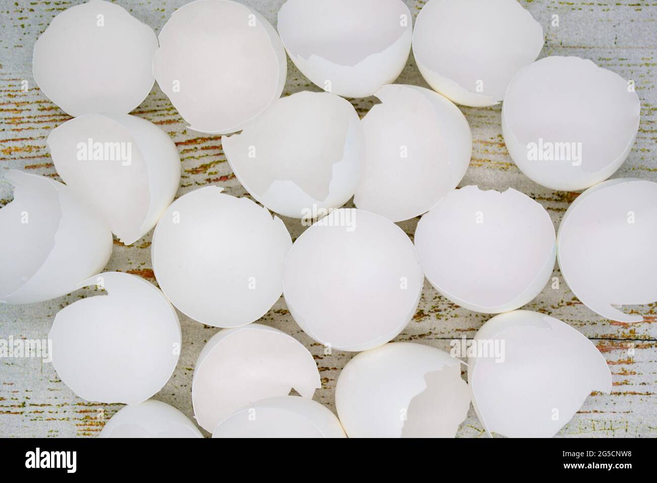 Close up top view of lots of broken white eggshells on an aged wood background. Stock Photo