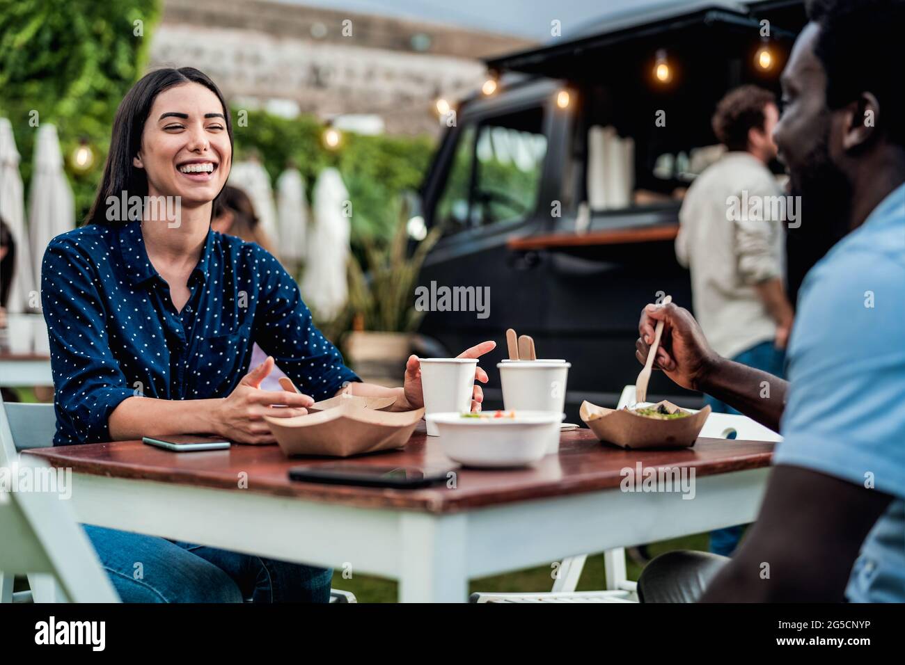 Happy multiracial friends having fun eating in a street food truck Stock Photo
