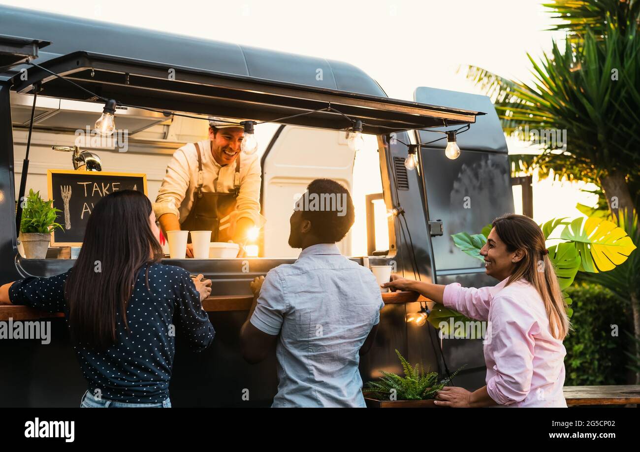 Young people buying meal from street food truck - Modern business and take away concept Stock Photo