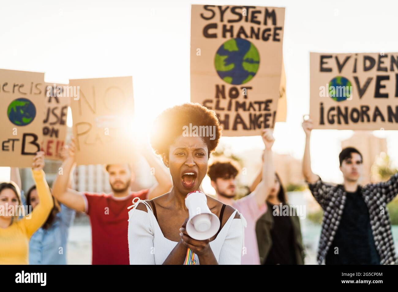 Demonstrators group protesting against plastic pollution and climate change - Multiracial people fighting on road holding banners Stock Photo