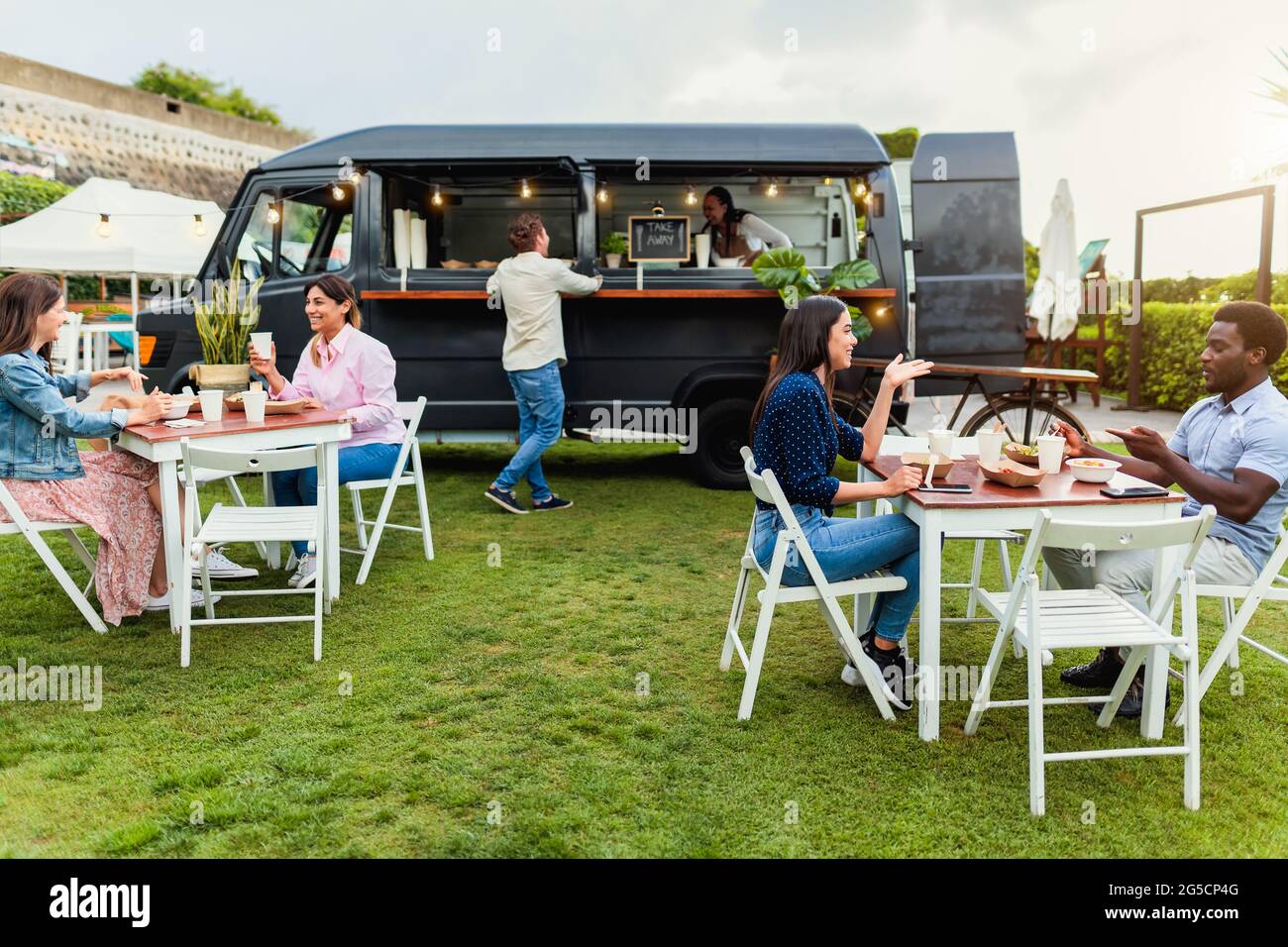 Happy multiracial people having fun eating in a food truck Stock Photo