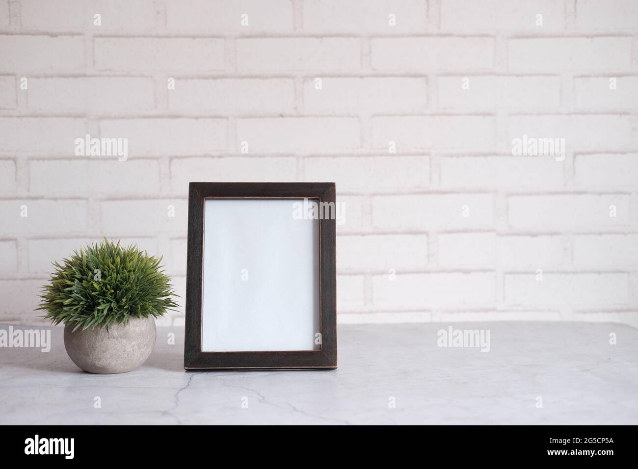 empty frame on table against white wall Stock Photo