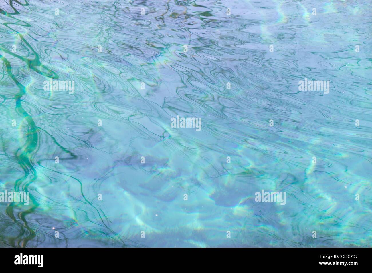Blue water background with reflections of the sun Stock Photo - Alamy