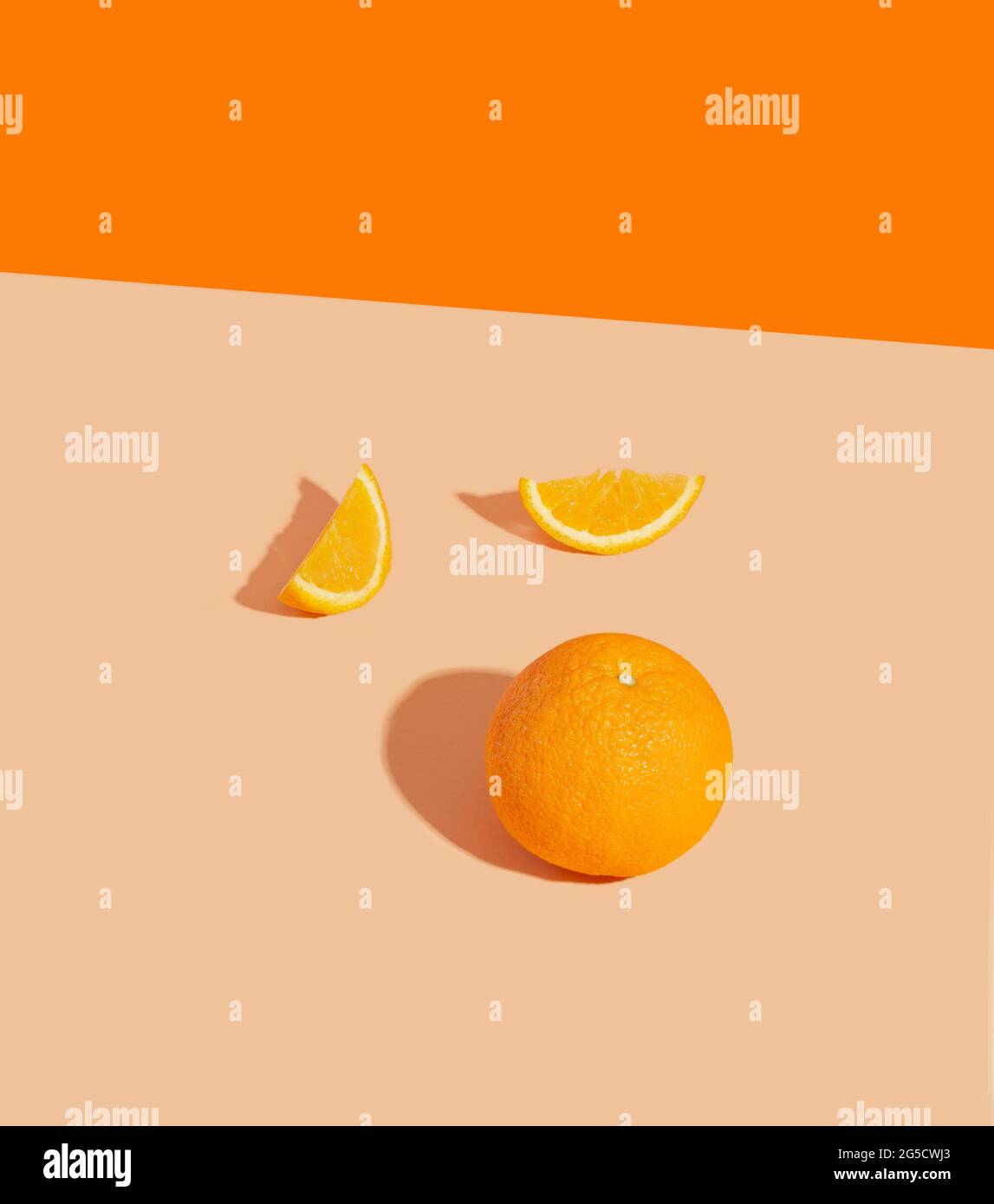 Whole orange and 2 slices on a bed background. The concept of a juicy and bright summer. Stock Photo