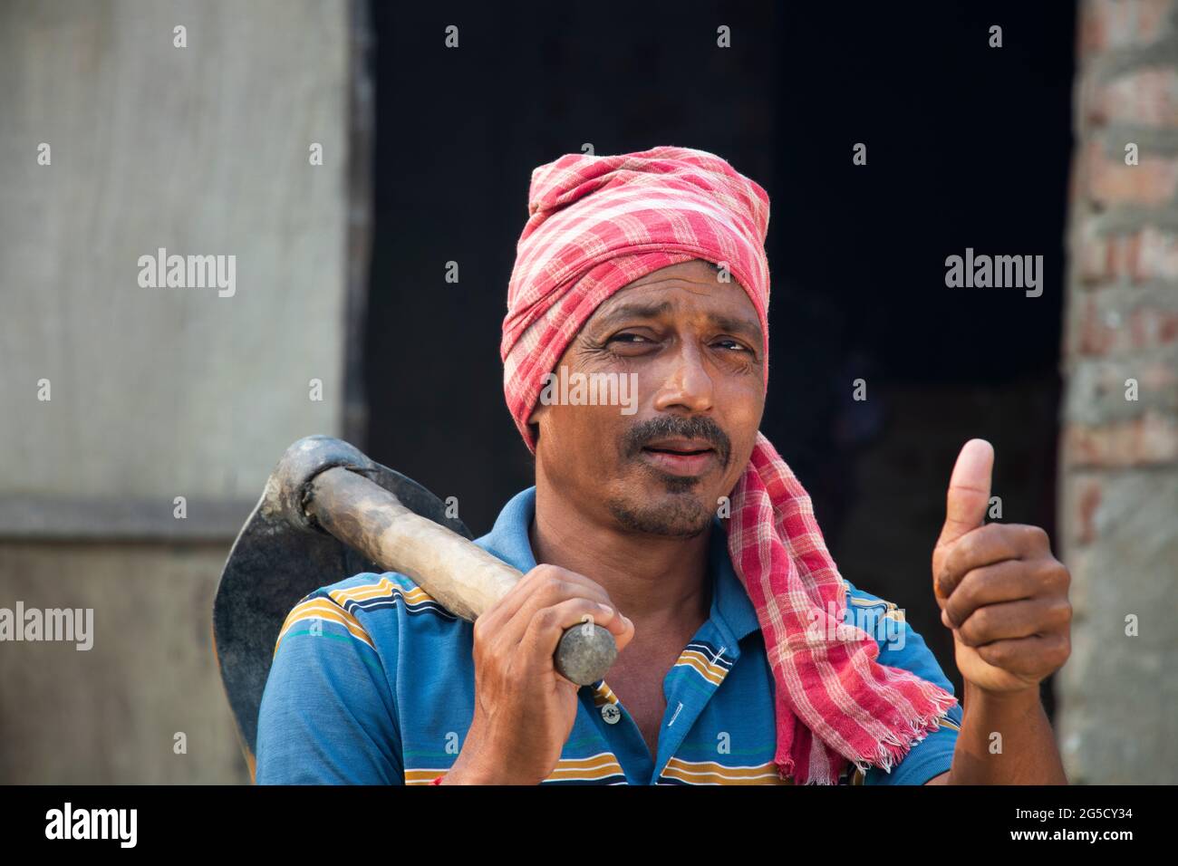 Portrait of a Farmer holding a Shovel showing thumbs up sign Stock ...