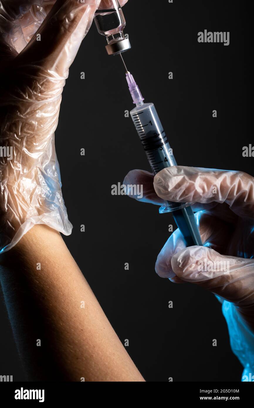 hands holding syringe and vaccine bottle Stock Photo