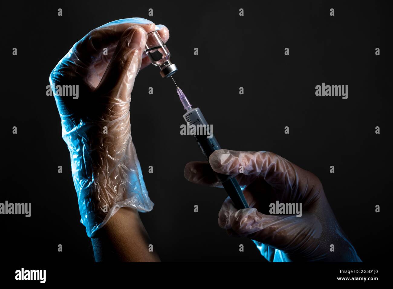 hands holding syringe and vaccine bottle Stock Photo