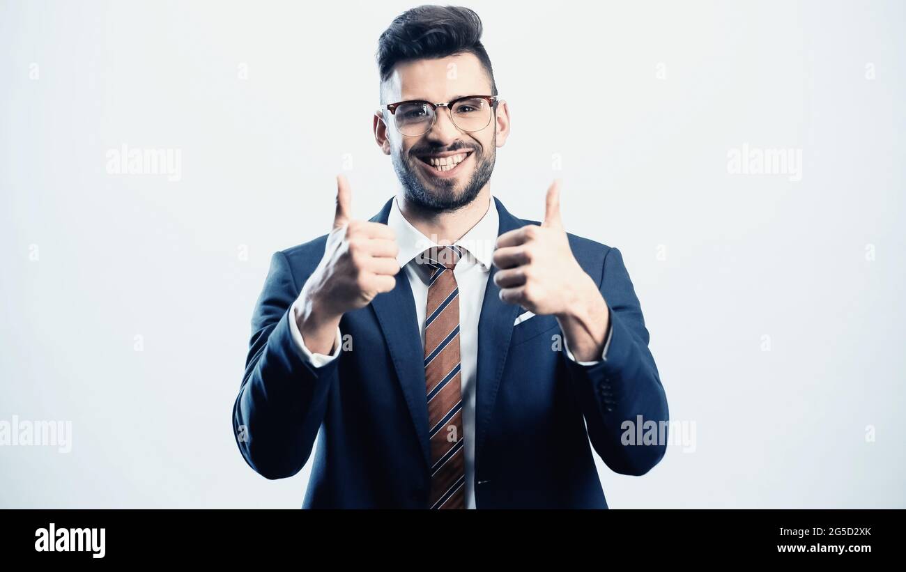 successful businessman showing thumbs up while smiling at camera ...