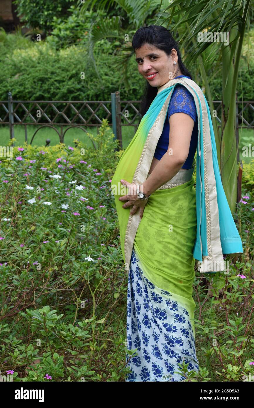 https://c8.alamy.com/comp/2G5D5A3/indian-young-pregnant-woman-posing-in-a-sari-in-a-park-mumbai-india-2G5D5A3.jpg