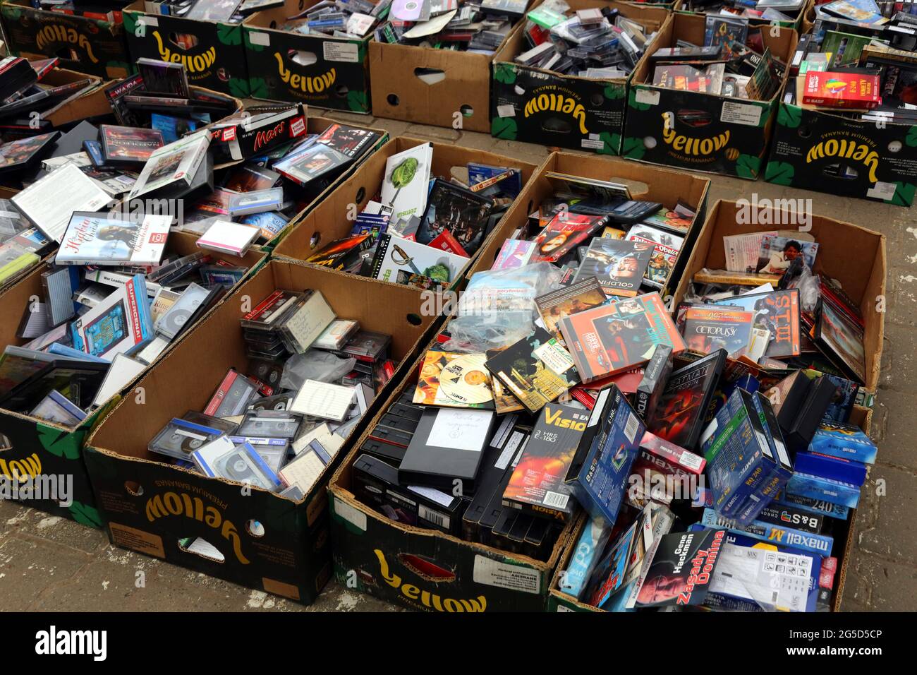 Flea market stand. Boxes full of old cassettes. Audio, VHS, CD, DVD. Stock Photo