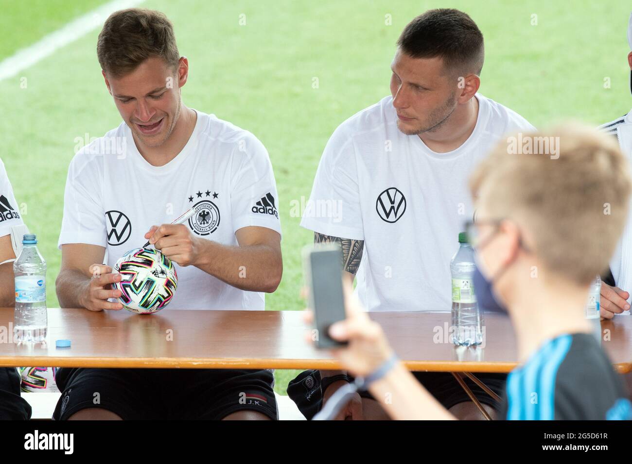 Herzogenaurach, Germany. 26th June, 2021. Football: European Championship, autograph session of the German national team at the Adi Dassler sports ground. Germany's Joshua Kimmich (l) and Niklas Süle sign balls during an autograph session. Credit: Federico Gambarini/dpa/Alamy Live News Stock Photo