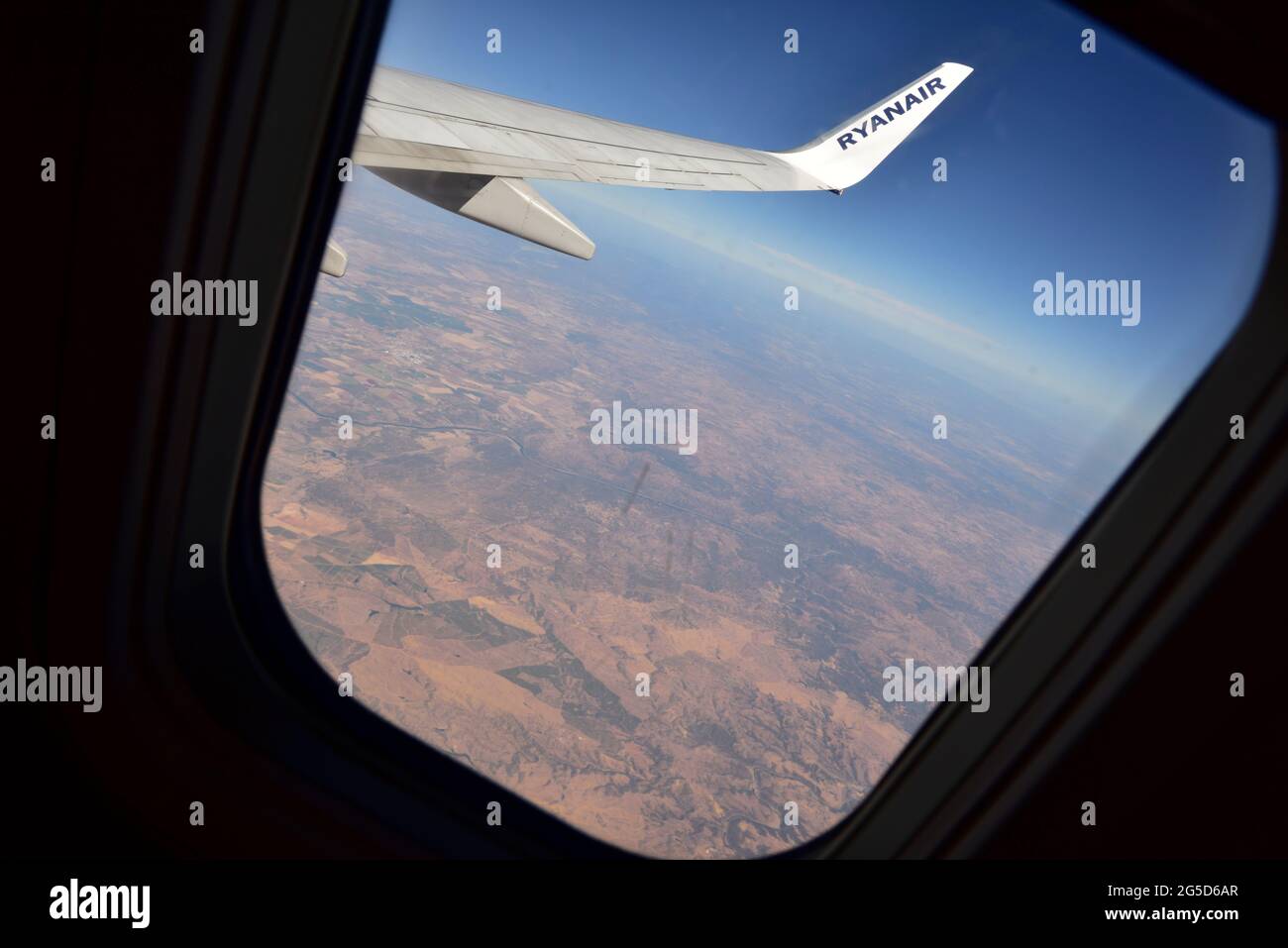 Looking out of a Ryanair window toward distant land Stock Photo