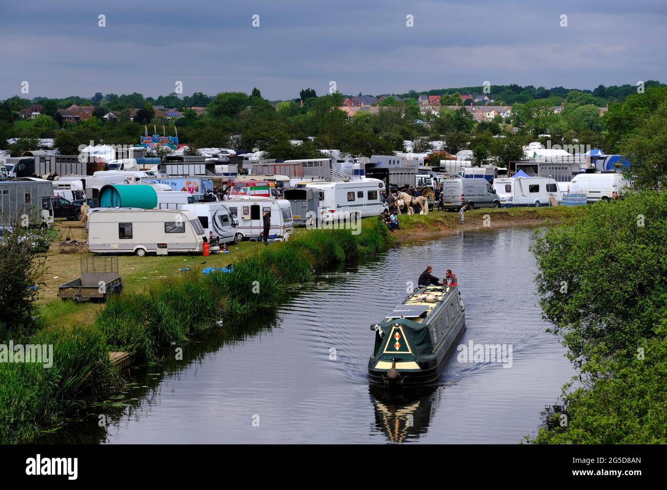 Mountsorrel, Leicestershire, UK. 26th June 2021. A narrow boat passes the Betty Hensers Horse Fair. Leicestershire Police and Charnwood Borough Council are working together to offer guidance and support to the organisers after concerns about possible breaches in Covid-19 regulations and the impact on local communities. Credit Darren Staples/Alamy Live News. Stock Photo