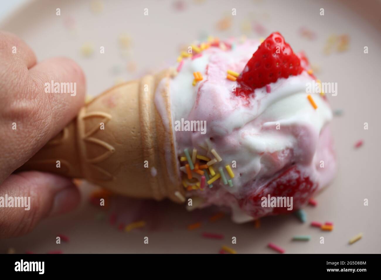 Close-up of a hand holding a Fresh Strawberry Ice-Cream Stock Photo