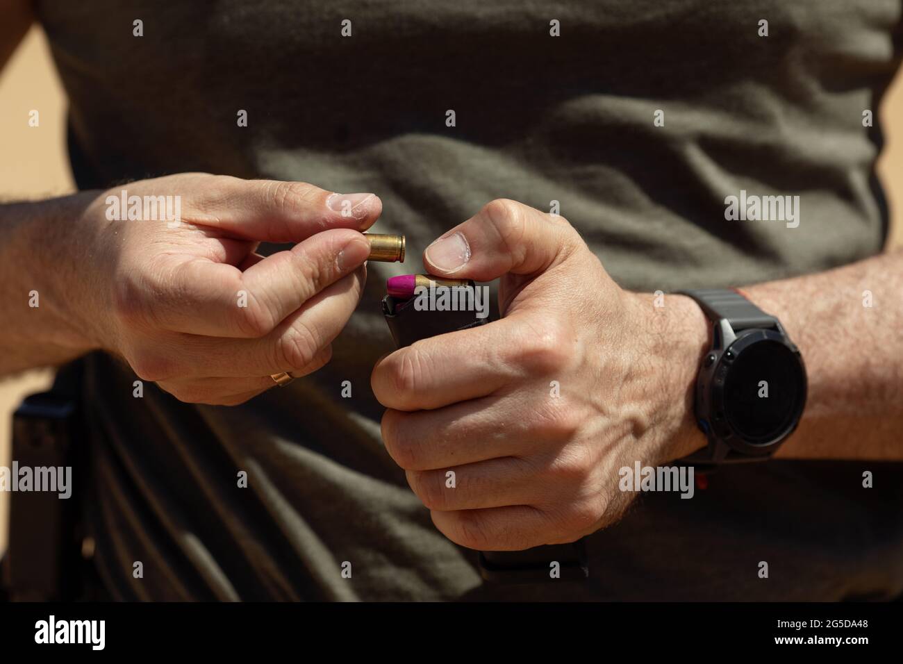 Close up of men hands loading ammo in magazine Stock Photo - Alamy