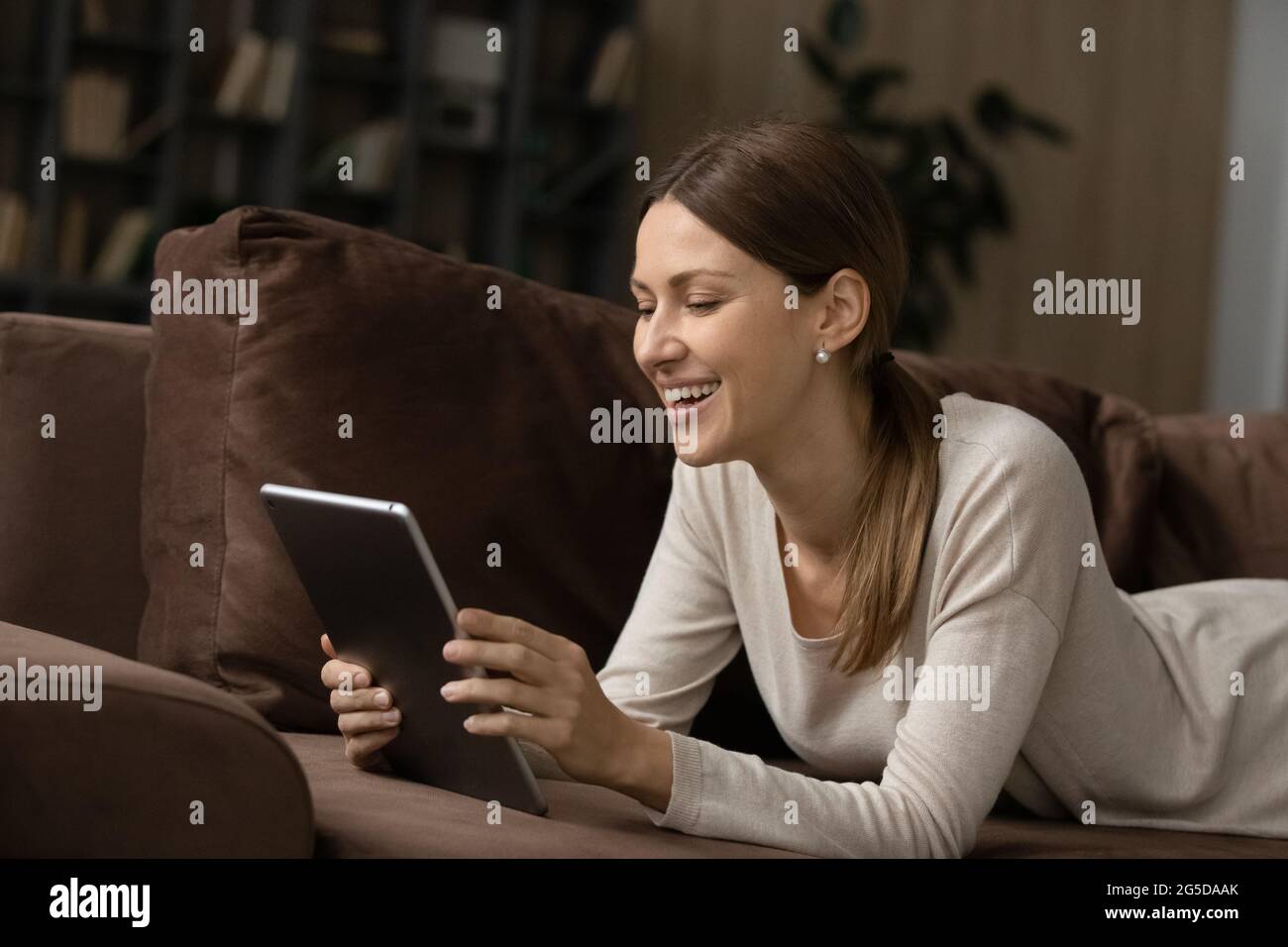 Cheerful young woman using digital computer tablet. Stock Photo